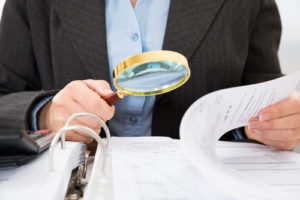 attorney reading documents with magnifying glass